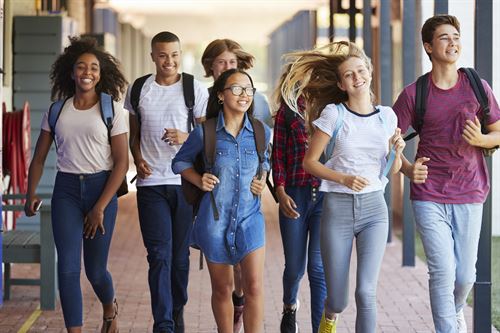 students walking down the hallway wearing their backpacks